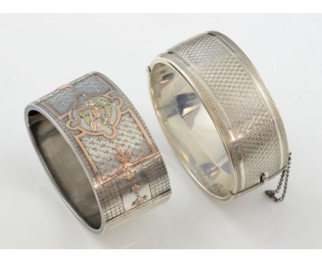 Two silver bangles, one with applied detail in rose gold, stamped sterling, and another with engine turned decoration .      