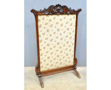 Regency mahogany fire screen with carved scroll and shell decoration on four hoof shaped feet, with later embroidered central
