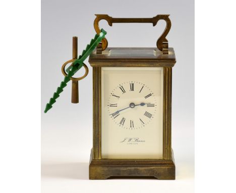 Brass carriage clock with black Roman numerals, on a white enamel dial, four glass sides, marked for Benson, London. 11cm hig