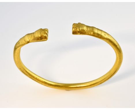 Engraved oval torque bangle, engraved detail ends, in yellow metal testing as 18ct or higher .     Gross weight 66.90Slightly