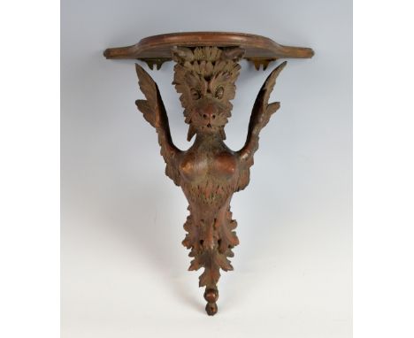 19th century carved wood wall bracket the support carved as a grotesque winged figure. 30cm high, 23cm wide, 15cm deep.     