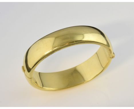 Oval hinged bangle, measuring 1.7cm wide, with hidden clasp, in yellow metal stamped 18 ct.     weight 76.3 gramslight surfac
