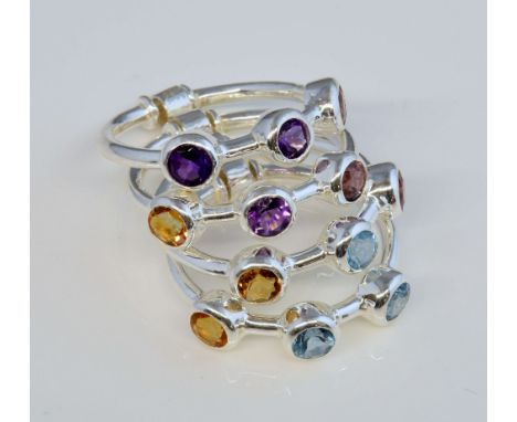 Gemstone set stacking rings, four individual rings connected together, each set with three round cut stones, including, blue 