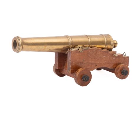 A 20th Century brass desk cannon. Mounted on a wooden carriage with wheels, 10cm high, 27cm long.