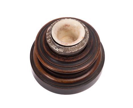 A late 19th century inkwell on wooden stand with steel rivet liner engraved and dated "HMS Powerful, 1895", diameter 10.9 cm.