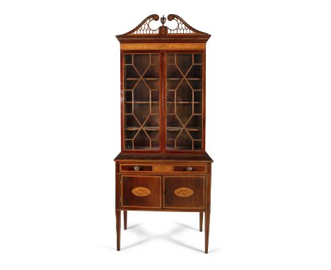A 'SHERATON' INLAID MAHOGANY BOOKCASE, 19th century, with pierced swan neck pediment above twin glazed panel doors, enclosing