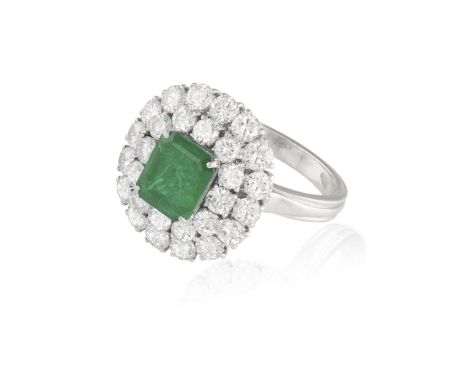 AN EMERALD AND DIAMOND CLUSTER RING, the rectangular cut-cornered emerald weighing approximately 1.30ct, within a surround of