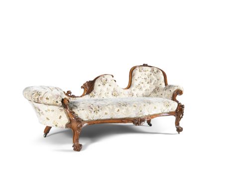 A VICTORIAN MAHOGANY FRAMED CHAISE LONGUE, mid 19th century, with button back upholstered in beige floral fabric, on carved s