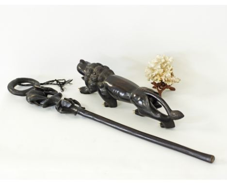 An African walking stick carved with elephants and stained black L84cm, together with a carved black hardwood lion (probably 