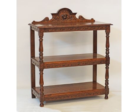 A Flemish / Dutch Renaissance style carved oak three tier console / étagère / dumb waiter, the arched back carved with leafy 
