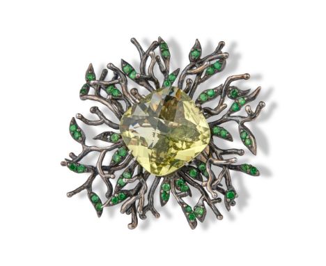 Silver ring centred on a light green cushion stone surrounded by tsavorites.Ring size: 55Diameter of the head : 5 cmGross wei