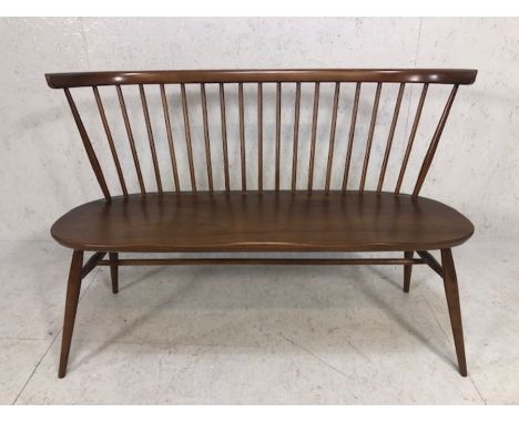 ERCOL Model 450 elm love seat / hall bench with spindle back, shaped top rail, twin saddle seat and raised on splayed legs wi