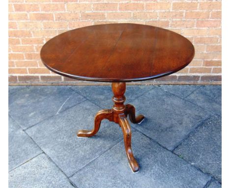 A TILT TOP OAK TABLE,  the circular top 89cm diameter, on tripod base, 74cm high