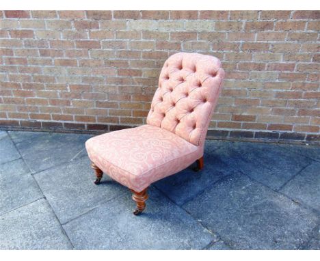 A VICTORIAN UPHOLSTERED BUTTON BACK NURSING/BEDROOM CHAIR on turned frontal supports with castors