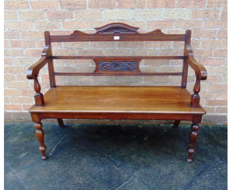 AN EDWARDIAN MAHOGANY HALL BENCH  with carved decoration on turned supports, 122cm wide 55cm deep 96cm high
