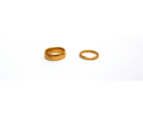 A 22 CARAT GOLD PLAIN WEDDING RING with another smaller narrower 22ct gold wedding ring; 14.1g gross