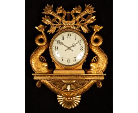 A Swedish style gilt framed wall clock, the circular dial with Arabic numerals flanked by dolphin supports and crest of torch