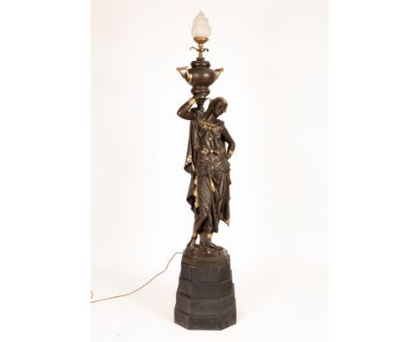 A spelter figural floor lamp modelled as a female figure with an urn on her shoulder, the urn with opaque glass flame-shaped 