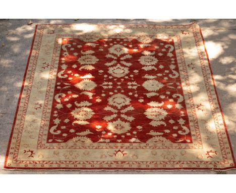 A Ziegler design carpet, Pakistan, the madder field with all-over palmettes and serrated leaves framed by an ivory palmette b