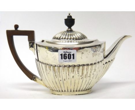 A silver teapot of oval form, with partly fluted decoration and with a black handle, Sheffield 1904, gross weight 488gms. 