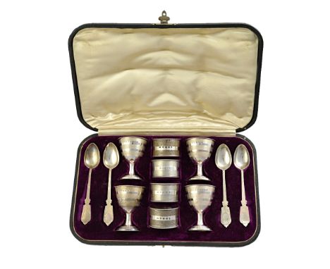 A Victorian silver egg cup and spoon set, comprising; four egg cups, four spoons and four napkin rings, each with engine turn