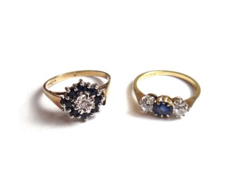 An 18ct gold, sapphire and diamond set three stone ring, claw set with the cushion shaped sapphire at the centre, between two