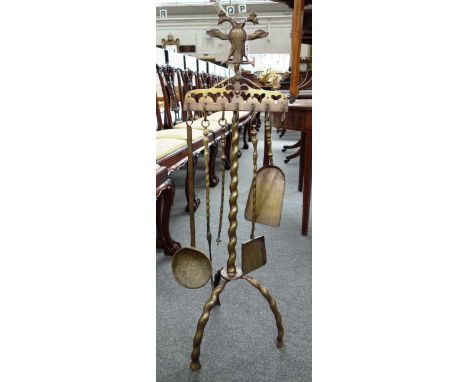 A bronze fire side compendium with Prussian eagle crest over fire tools on a triform base, 101cm high.