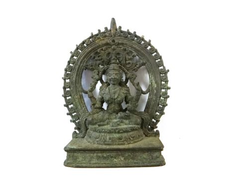 A Kerala bronze figure of Gajalakshmi, South India, 16th/17th century, seated wearing a tall tiered headdress with one hand i
