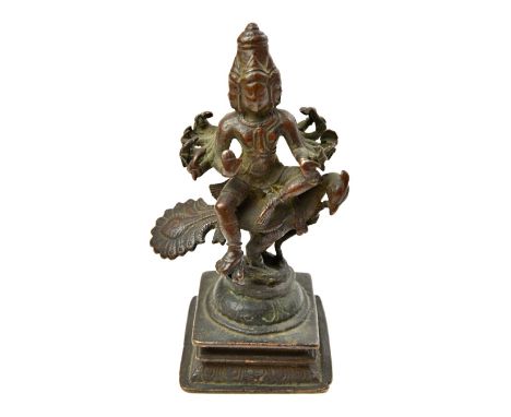 A bronze figure of Skanda, South Indian, probably 16th century, the multi-armed and multi-head god seated on the back of his 