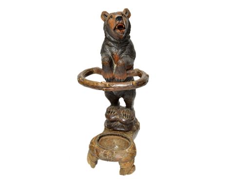 A 19th century carved lime wood Black Forest stick stand in the form of a standing bear, 90cm wide.  Illustrated