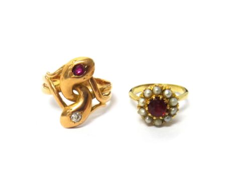 A gold, diamond and ruby set ring, designed as two entwined serpents, mounted with a cushion shaped diamond and with a cushio