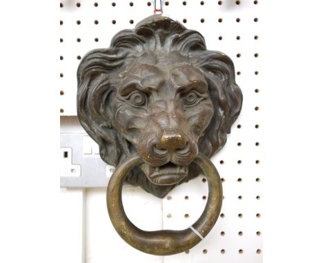 A Victorian patinated bronze door knocker of large proportions, modelled and cast as a lion's head, with ring handle through 