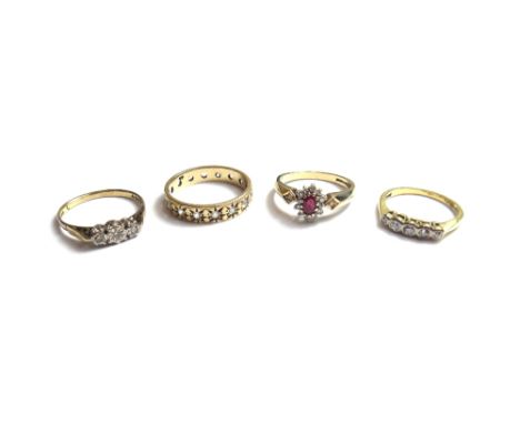 A 9ct gold, ruby and diamond set oval cluster ring, claw set, with the oval cut ruby at the centre, a gold and diamond set fi