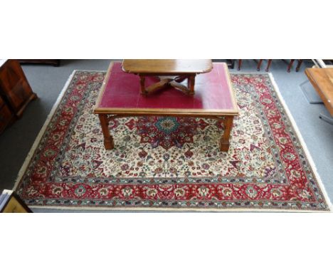 A Tabriz carpet, Persian, the ivory field with a bold burgundy medallion, pale indigo spandrels; all with abundantly floral s