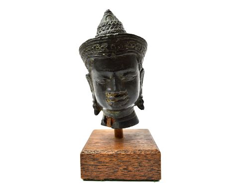 A small Khmer bronze head of buddha,Angkor Wat style,  probably 13th century, wearing a conical headdress with wide forehead 