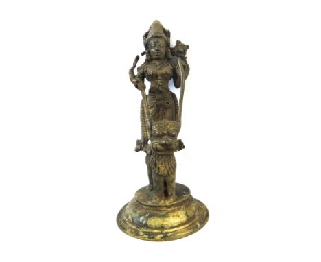 A Kerala bronze figure of Durga, South India, 19th century, the goddess standing on the back of a lion, raised on a circular 