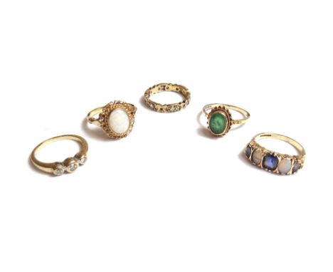 A 9ct gold ring, mounted with an oval opal, a 9ct gold and diamond set three stone ring, a 9ct gold, opal and blue gem set fi