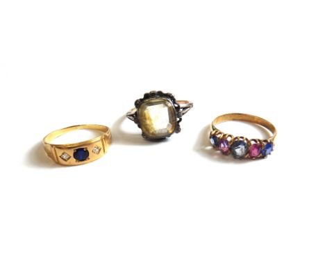 A gold, diamond and synthetic sapphire set three stone ring, a gold, Ceylon and pink sapphire set five stone ring and a citri