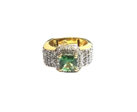 A 14ct gold, diamond and green gemstone set dress ring, claw set with the cushion shaped green gemstone at the centre, the tw