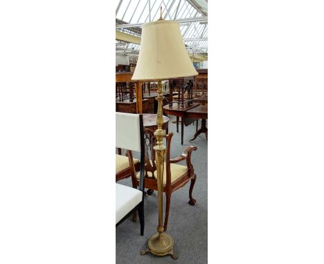 An early 20th century gilt metal standard lamp with ram's head mounts on lion paw feet, 179cm high.