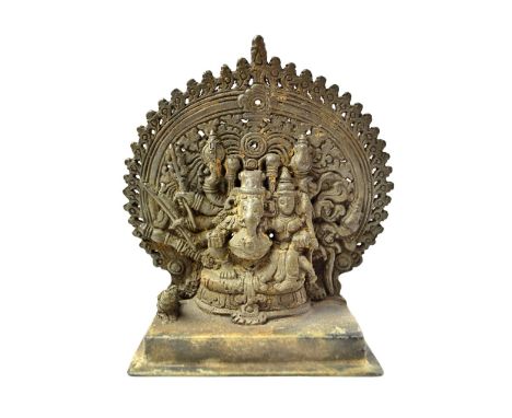 A Kerala bronze group of Mahaganapati, South India, 17th century, seated with multi-arms before an aureole, his consort at hi