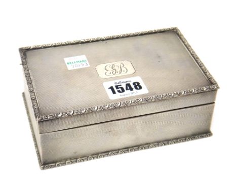 A silver rectangular table cigarette box, the cover and the sides engine turned within floral moulded borders, wooden lined w