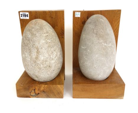 A pair of contemporary oak bookends, each mounted with a granite boulder, 27cm high, (2). 