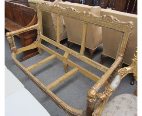 A 19th century gilt framed sofa frame with carved serpent crest rail, bow seat and turned supports, 180cm wide.