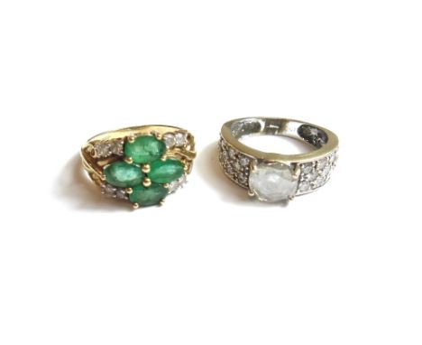 A 9ct gold, emerald and diamond set ring, claw set with four oval cut emeralds, between two pairs of circular cut diamonds to