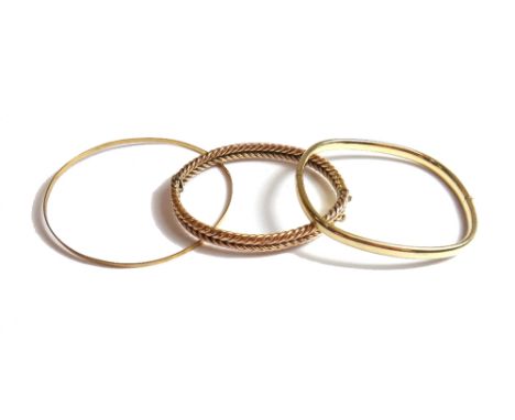 A gold oval hinged bangle of herring bone form, on a snap clasp, detailed 9, a 9ct gold circular bangle and a 9ct gold oval h