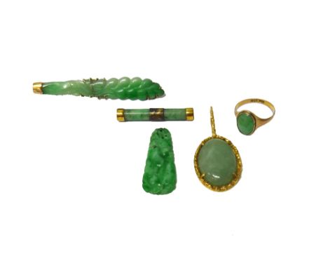 An Oriental gold mounted carved jade brooch, a jade brooch of baton form, a gold ring mounted with an oval jade and three fur