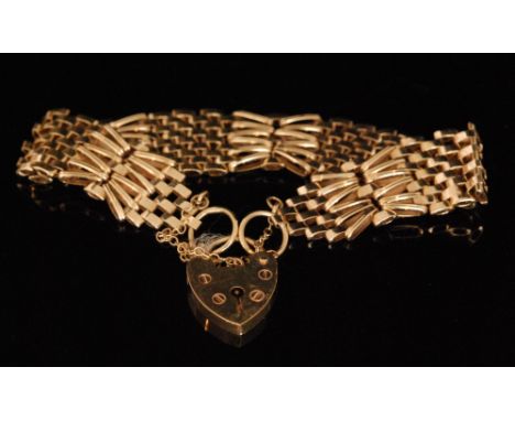 A modern 9ct linked panel and cross bar fancy gate bracelet, terminating in padlock fastener, weight 16g. 