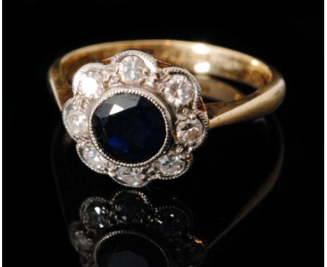 A mid 20th Century 18ct sapphire and diamond daisy cluster ring, central millegrain set circular sapphire within a eight ston