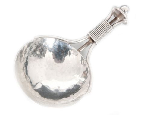 An Arts and Crafts hallmarked silver caddy spoon with circular spot hammered bowl, the handle formed of three wirework bound 